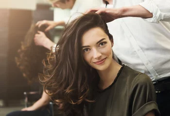Foto auf Acrylglas Friseur Frau sitzt im Schönheitssalon und macht Frisur