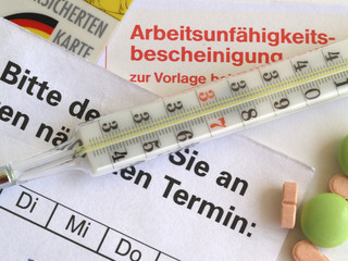 Krankenschein mit Fieberthermometer, Tabletten, Terminkarte und Krankenversichertenkarte