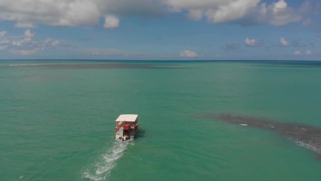 Back view of Boat sailing on greenish blue sea in Para&iacute;ba, Brazil