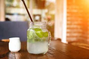 Fresh drink lemonade mojito on wooden table. Mojitos with mint leaves, lime and ice, outdoor.