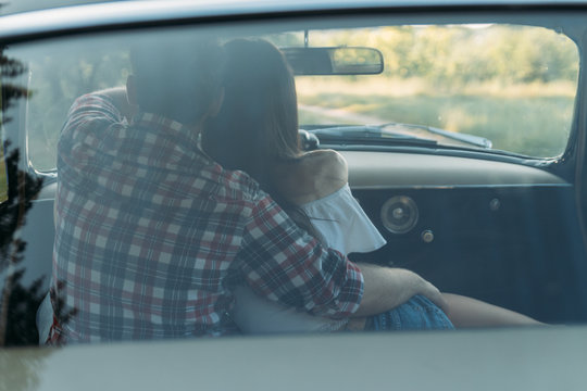 couple, man and woman are sitting in the car, the guy is hugging the girl. traveling together