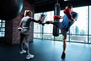 Work all day. Appealing athletic fitness trainer feeling extremely busy while working all day with her client