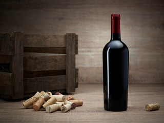 Weinflasche mit Weinkiste und Korken auf Holztisch