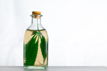 Infusion on the leaves of marijuana in a jar on a white background.