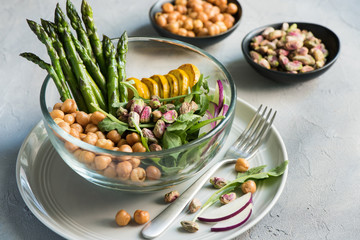 Vegetarian salad, Buddha bowl with asparagus, arugula, zucchini, kohlrabi, pistachio and chickpeas. Selective focus