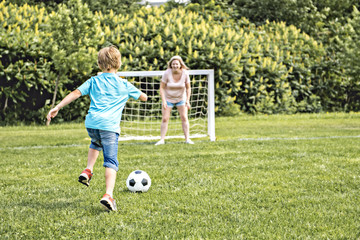 boy playing football outdoor on a summer day