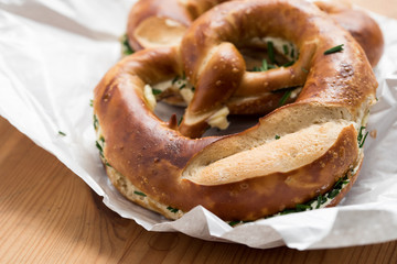 Schwäbische Brezel mit Butter und Schnittlauch auf Bäckertüte