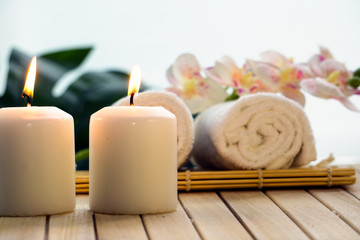 white towel, leaf of a palm tree, decorative cosmetics on a light background top view, spa