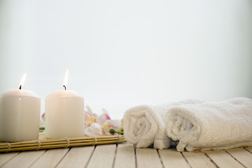 Fototapeta na wymiar Spa setting still life with orchid flower , candle, soap and towels on white background