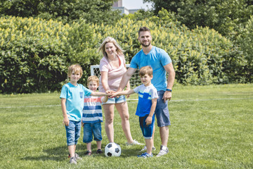 Fototapeta premium Man with child playing football outside on field