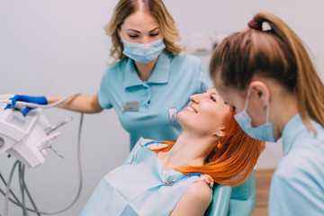 young red-haired woman at reception with dentist