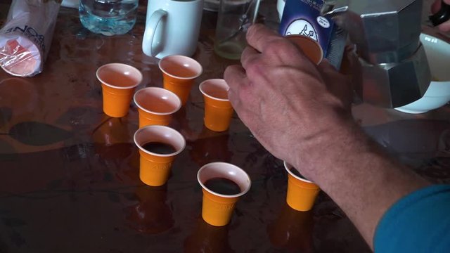 A shot of coffee being served in small shot glass.