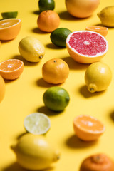 Citrus fuits, grapefruit, lemon, lime, orange on a yellow background