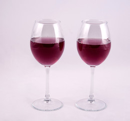 two glasses of red wine on white background