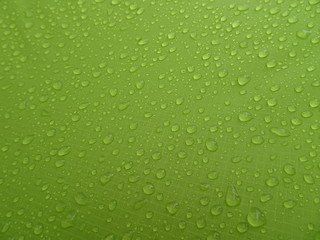 Naklejka na ściany i meble Texture: a drop of water on a green fabric. Water-repellent effect. Waterproof textile