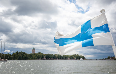 A Finnish flag on a boat, develops in the wind with a view of the sea. Travel to Finland,...
