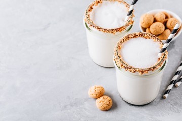 Obraz na płótnie Canvas Vanilla milkshake with crispy cookies in glass mason jar on gray background
