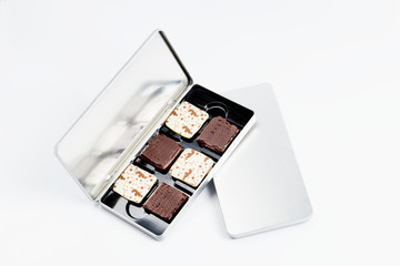 Chocolate in an iron box, on a white background.