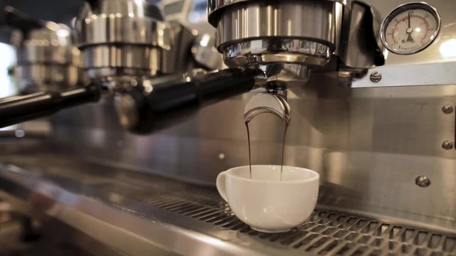 Fresh espresso pours into a mug on a beautiful espresso machine