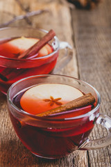 Hot drink with apple cider, sliced fruit and cinnamon stick