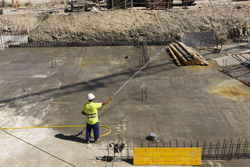 Obrero regando el hormigonado en una obra.
