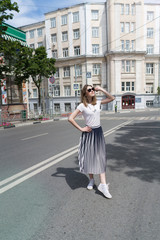 Summer sunny lifestyle fashion portrait of young stylish hipster woman walking on the street,