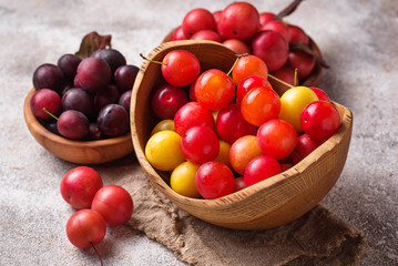 Various type of cherry-plum in wooden bowls 