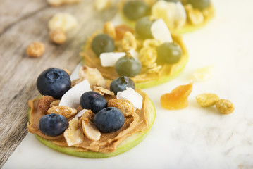 Healthy Sandwich. Green apple rounds with peanut butter and blueberries on rustic table Health and Dietting