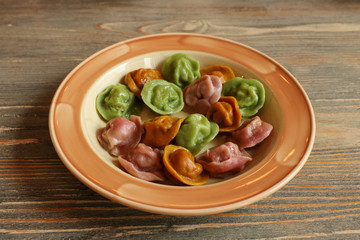 Boiled colored dumplings on a ceramic plate on a table
