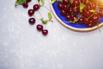Beautiful texture, background with ripe cherries in a plate, top view