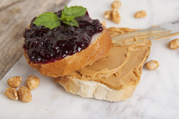 Peanut butter and raspberry jelly sandwich on white background. Sweet breakfast or snack. Close up.