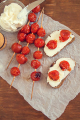 woman preparing sandwiches with cream cheese and tomatoes