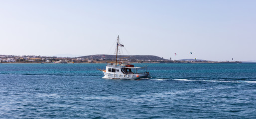 Greece. Aegean sea, Cyclades. Boat travelling, kite surfers and blue sky and sea background