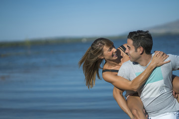 Fototapeta premium Romantic couple playing outdoors by the lake