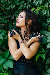 Portrait of young sexy brunette with black grapes.