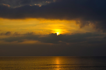 Dramatic light mood with orange illuminated clouds and the sun as a fiery ball during a sunrise over the Baltic Sea in Bansin on usedom, Germany