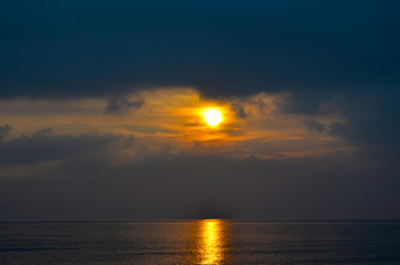Dramatic light mood with orange illuminated clouds and the sun as a fiery ball during a sunrise over the Baltic Sea in Bansin on usedom, Germany