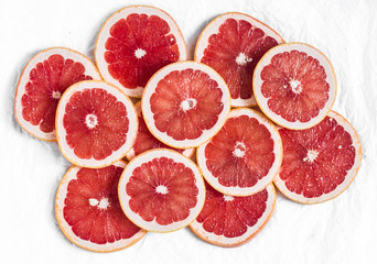 Fototapeta na wymiar Fresh grapefruit slices on a light background, top view. Copy space