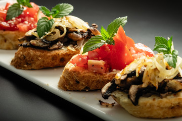 Fresh bruschetta assorted. Serve on a white plate. Order in the menu