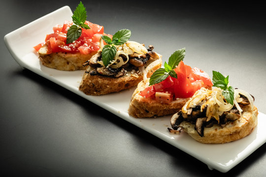 Fresh bruschetta assorted. Serve on a white plate. Order in the menu