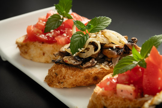 Fresh bruschetta assorted. Serve on a white plate. Order in the menu
