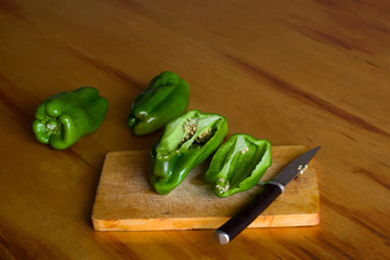 sliced green bell peppers on wooden board on wooden table