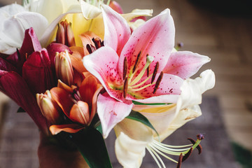 beautiful colorful lily flower bouquet on rustic wooden background. gorgeous bloom lilies on rustic...