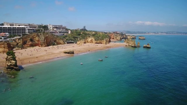 Aerial. Video from the air beach dona Ana, tourists sunbathe, sail boats