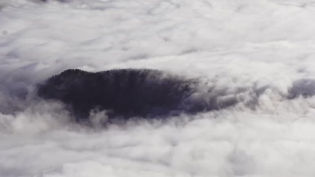 Beautiful 4k time lapse video of clouds flowing over a small hill.