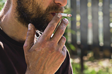 bearded man with a cigarette in his mouth