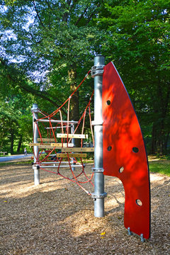 Climbing frame with equipment out of ropes, metal poles and plastic elements on a public playground in Berlin.