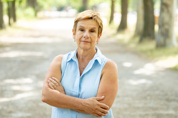Portrait of a serious emotional elderly woman in the park