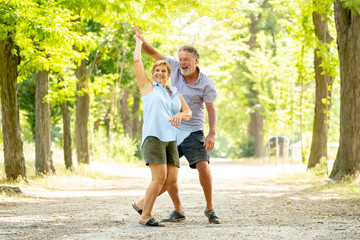 Portrait of a beautiful happy senior couple in love dancing in the park