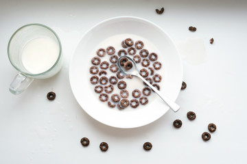 Morning breakfast milk, corn flakes on white background. Birds eye view